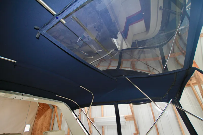 Slide: The Image of 1989 Tollycraft 34 Sport Sedan boat interior with blue canopy and metal supports. - 36