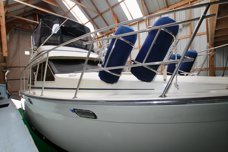 Slide: The Image of 1989 Tollycraft 34 Sport Sedan in storage, featuring blue fenders and sleek design. - 4