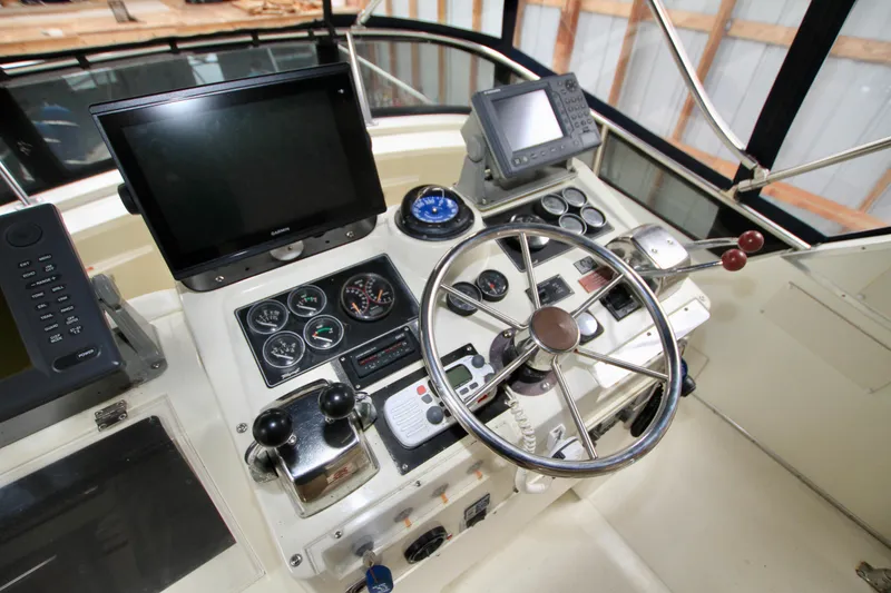 Slide: The Image of 1989 Tollycraft 34 Sport Sedan helm with steering wheel, gauges, and navigation equipment. - 40