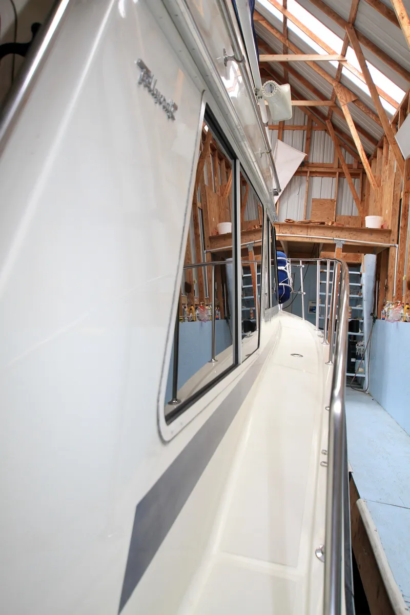 Slide: The Image of 1989 Tollycraft 34 Sport Sedan in a wooden boathouse, side view. - 46