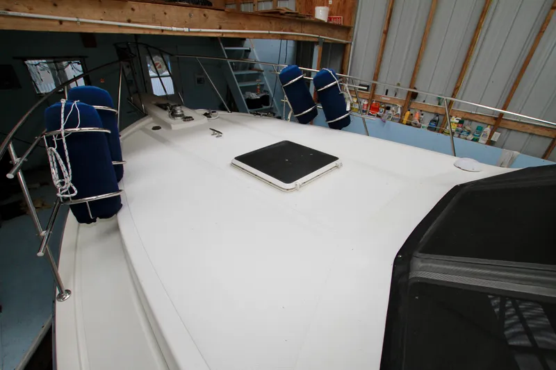 Slide: The Image of 1989 Tollycraft 34 Sport Sedan boat deck with blue fenders in a storage facility. - 50