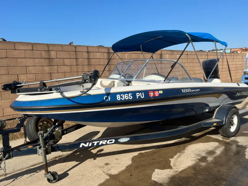 Slide: The Image of 2002 Nitro 188 Sport boat with blue canopy on trailer. - 0