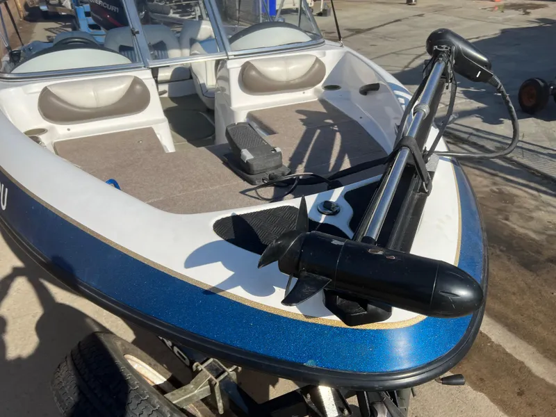 Slide: The Image of 2002 Nitro 188 Sport boat with trolling motor, blue and white design, parked on a trailer. - 12