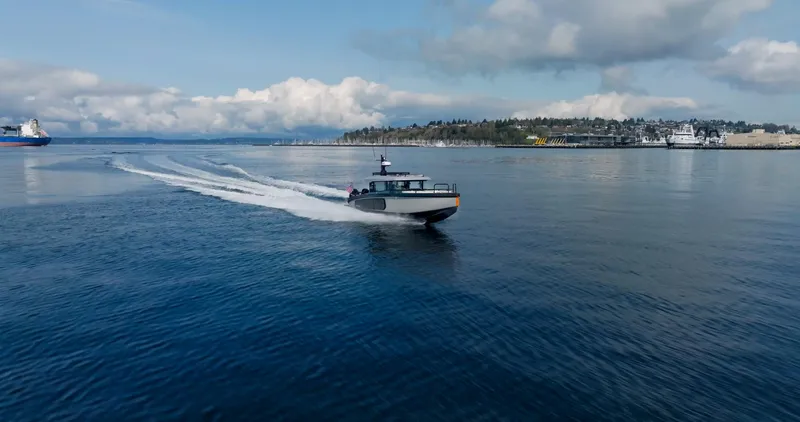 Slide: The Image of Arksen 30 boat cruising on open water, 2023 model, with scenic coastal backdrop. - 11