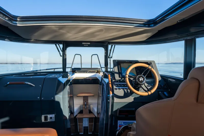 Slide: The Image of Interior view of 2023 Arksen 30 boat cockpit with steering wheel and navigation system. - 32