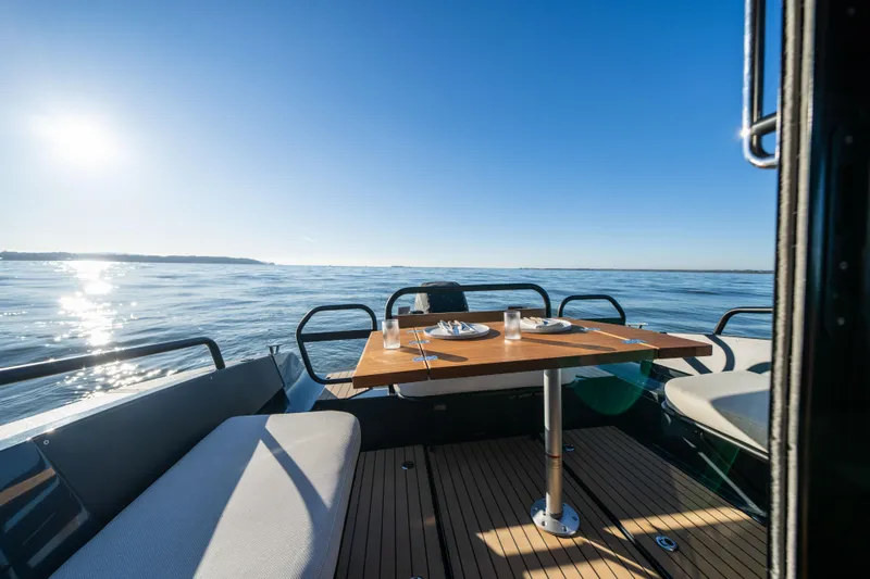 Slide: The Image of Arksen 30 boat interior with dining table, ocean view, and sunny sky, 2023 model. - 39