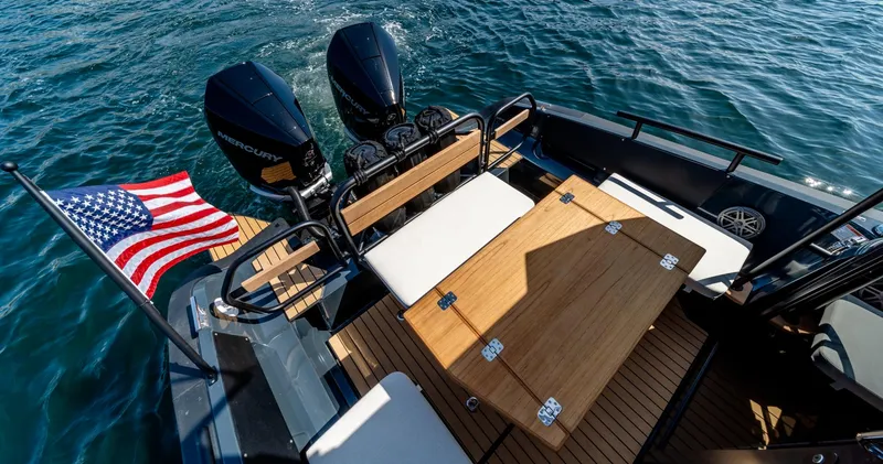 Slide: The Image of 2023 Arksen 30 boat with dual engines and American flag on open water. - 49
