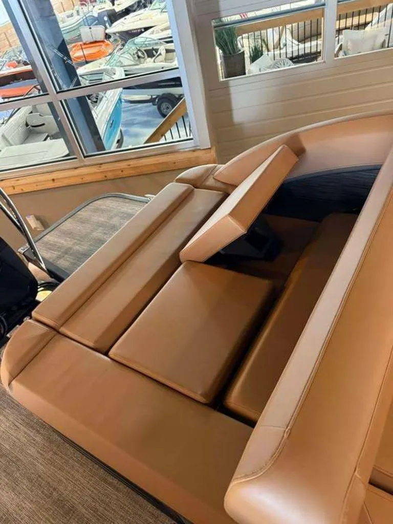 Slide: The Image of 2025 Bennington M Swingback 24 MSB boat interior with tan seating in showroom. - 7