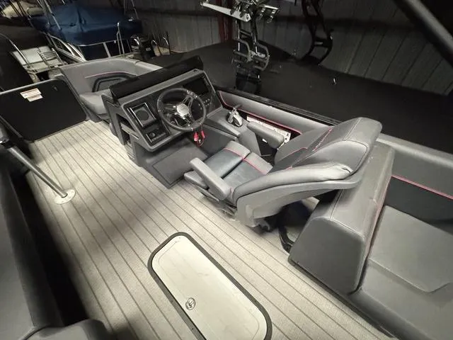 Slide: The Image of 2023 Manitou Explore 22 Max Bench interior with modern steering and seating. - 11