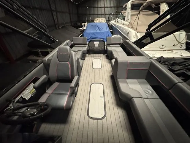 Slide: The Image of 2023 Manitou Explore 22 Max Bench pontoon boat interior in storage. - 14