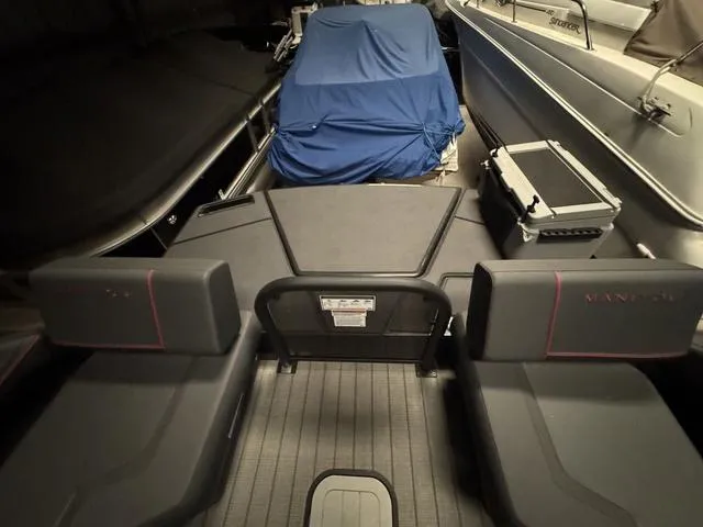 Slide: The Image of 2023 Manitou Explore 22 Max Bench interior with covered equipment, showcasing seating and deck layout. - 15