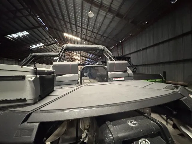 Slide: The Image of 2023 Manitou Explore 22 Max Bench pontoon boat in a warehouse setting. - 23