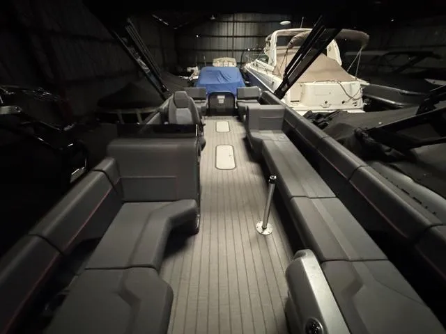 Slide: The Image of 2023 Manitou Explore 22 Max Bench interior with spacious seating in a dimly lit storage area. - 5
