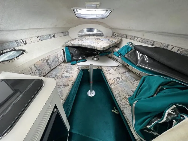 Slide: The Image of 2000 Glastron 249 boat interior with seating, table, and teal accents. - 15
