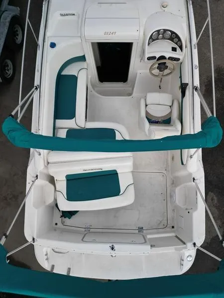 Slide: The Image of 2000 Glastron 249 boat interior with teal and white seating, steering wheel, and dashboard. - 18