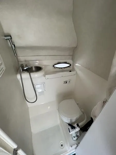 Slide: The Image of Compact bathroom in a 2000 Glastron 249 boat, featuring a toilet and sink. - 6