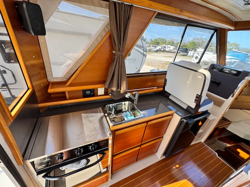 Slide: The Image of Interior of 2016 Cutwater C-28 boat featuring a compact kitchen with stove and sink. - 2