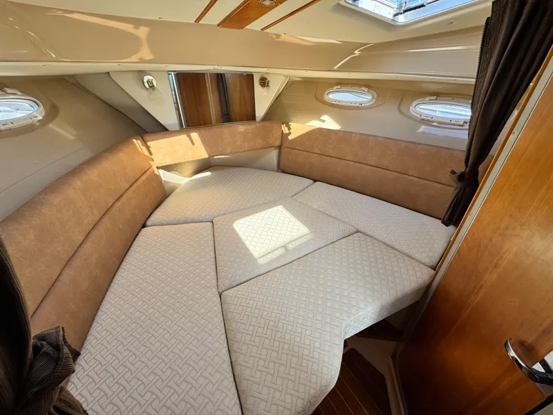 Slide: The Image of 2016 Cutwater C-28 cabin interior with beige cushions and wood accents. - 8