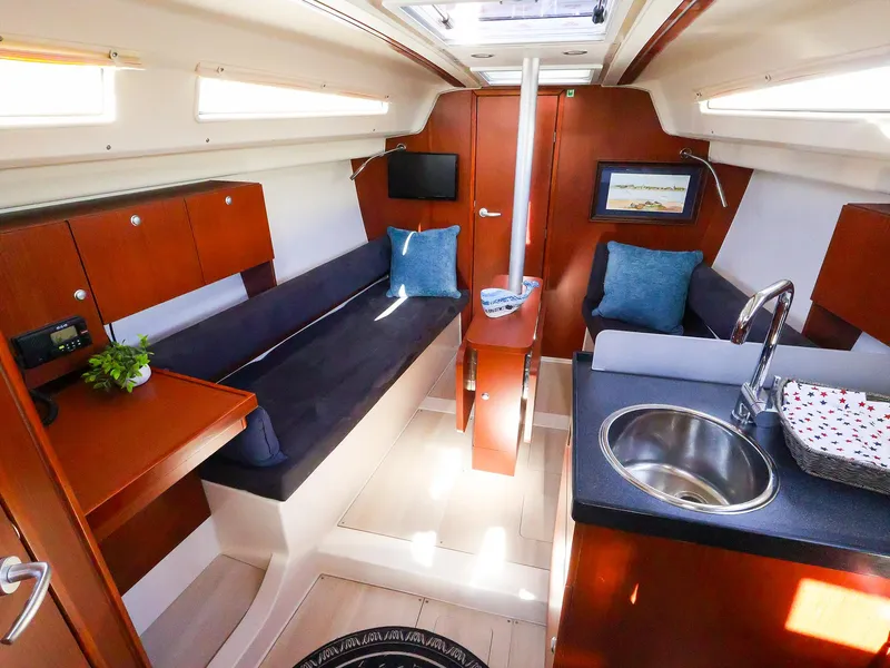 Slide: The Image of Interior of 2018 Hanse 315 yacht with modern furnishings and compact kitchen area. - 10