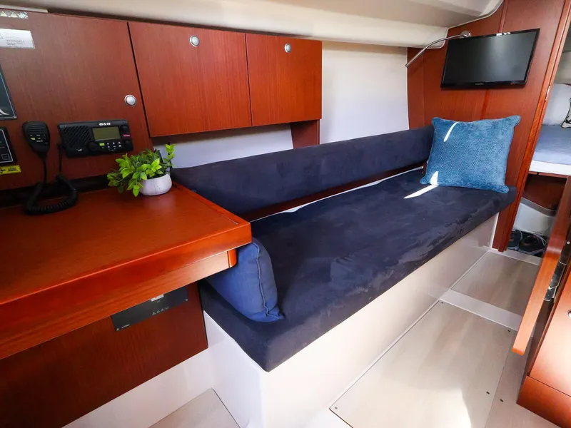 Slide: The Image of Interior of 2018 Hanse 315 yacht with sofa, wooden cabinets, and a small TV. - 17