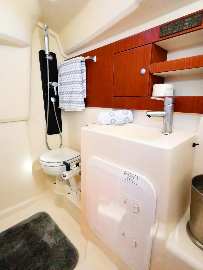 Slide: The Image of Compact bathroom in 2018 Hanse 315 yacht with modern fixtures and wooden cabinetry. - 22
