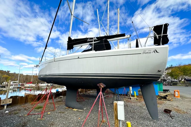 Slide: The Image of 2018 Hanse 315 sailboat on stands, marina background, clear sky. - 3