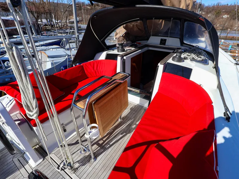 Slide: The Image of 2018 Hanse 315 yacht cockpit with red seating and wooden table. - 4