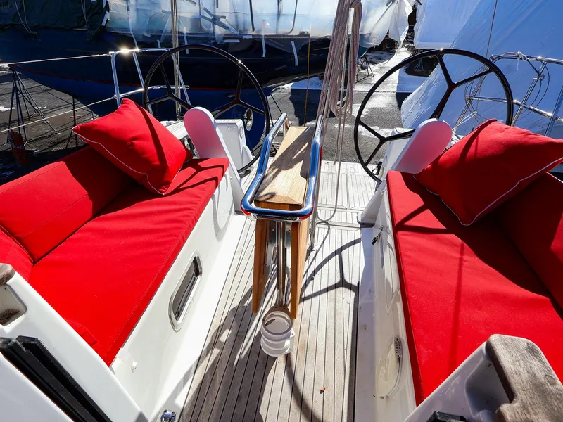 Slide: The Image of 2018 Hanse 315 yacht cockpit with red cushions and dual steering wheels. - 8
