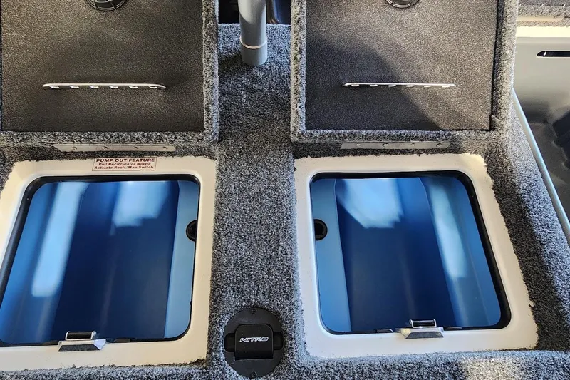 Slide: The Image of 2025 Nitro Z20 XL boat storage compartments with pump-out feature, open lids, and carpeted finish. - 12