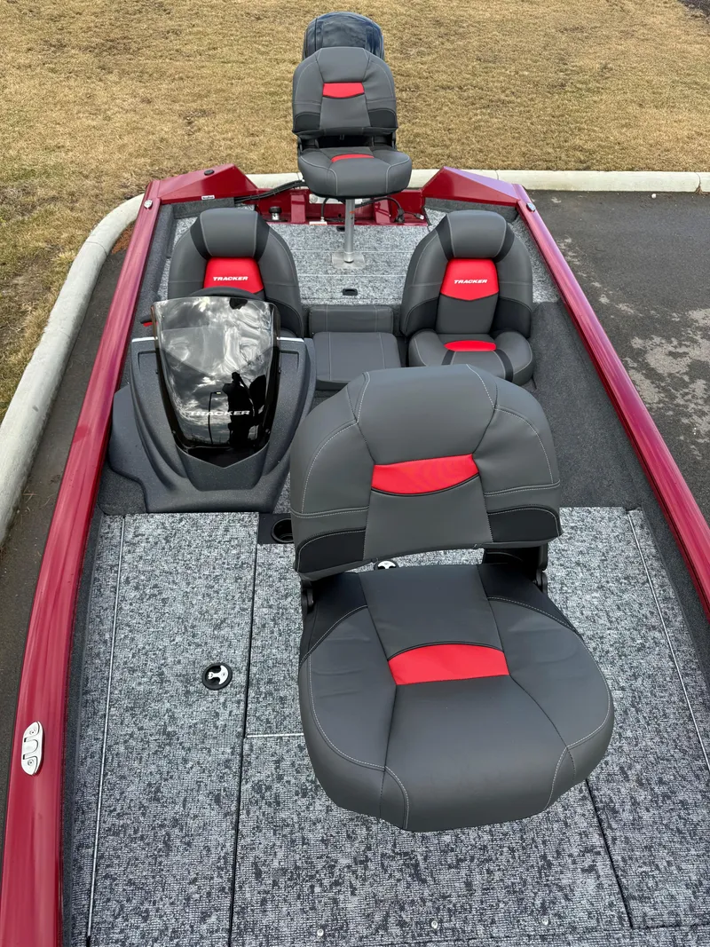 Slide: The Image of 2025 Tracker Pro Team 175 boat with red and gray seating, parked on pavement. - 4