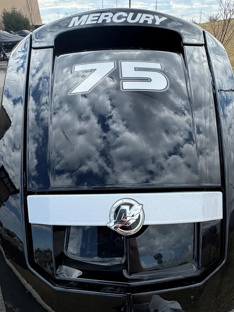 Slide: The Image of Mercury 75 horsepower engine on 2025 Tracker Pro Team 175 boat, reflecting cloudy sky. - 6