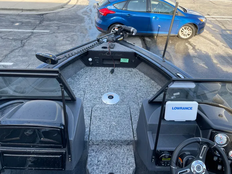 Slide: The Image of 2025 Tracker Targa V-18 WT boat interior with Lowrance system, parked near a blue car. - 4