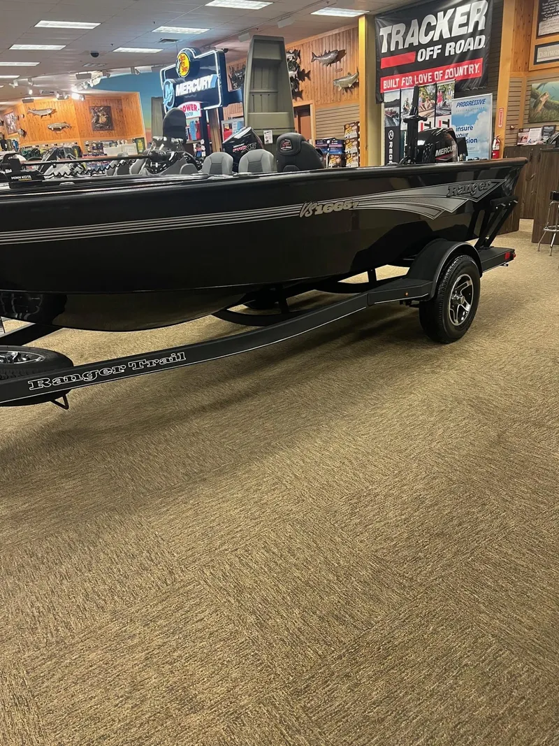 The Image of 2025 Ranger VS1665T boat on display in a showroom with various outdoor equipment. - 0