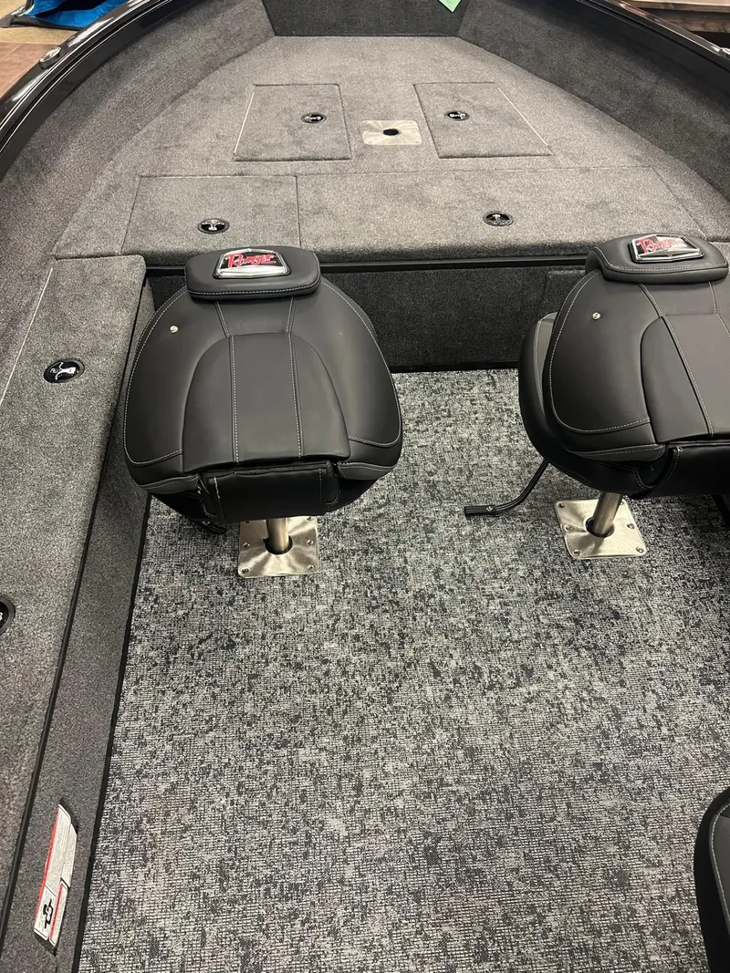 Slide: The Image of 2025 Ranger VS1665T boat interior with black seats and gray carpet. - 4