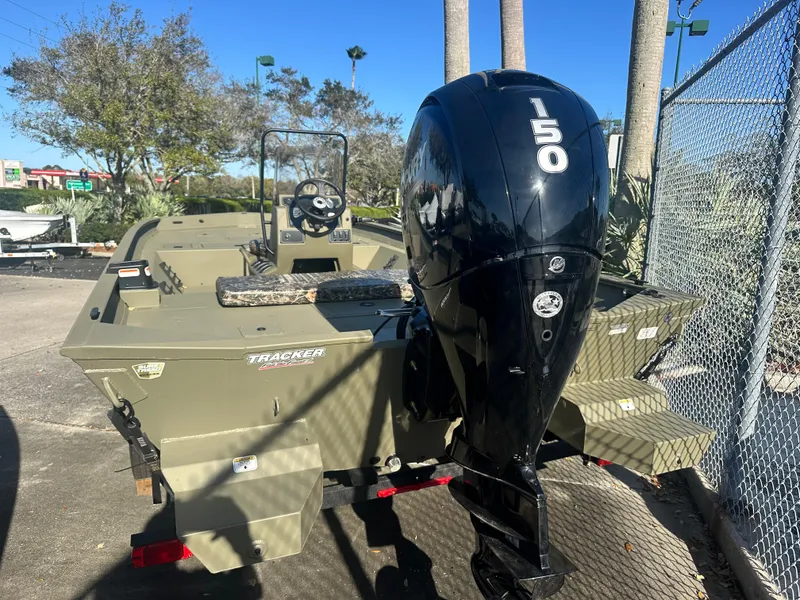 Slide: The Image of 2025 Tracker Grizzly 2072 CC boat with 150 HP engine, parked outdoors. - 2