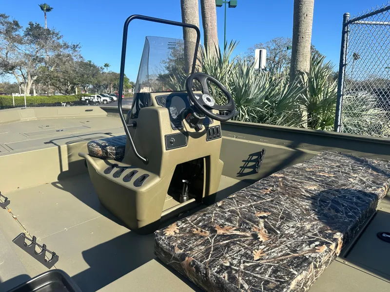 Slide: The Image of 2025 Tracker Grizzly 2072 CC boat interior with camo seating and steering console. - 3
