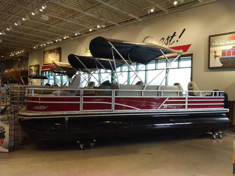 Slide: The Image of 2025 Ranger Reata 223F pontoon boat displayed indoors with canopy and seating. - 0