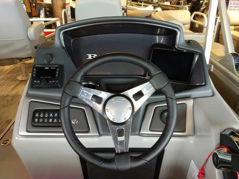 Slide: The Image of 2025 Ranger Reata 223F boat dashboard with steering wheel and control panel. - 8