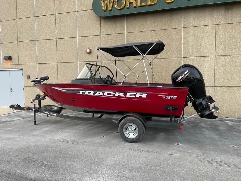 The Image of 2025 Tracker Pro Guide V-175 Combo boat with canopy on trailer, parked outdoors. - 0