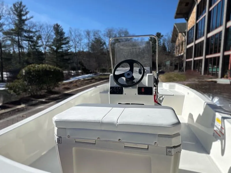 Slide: The Image of 2025 Mako Pro Skiff 15 CC boat interior with steering wheel and seating. - 4