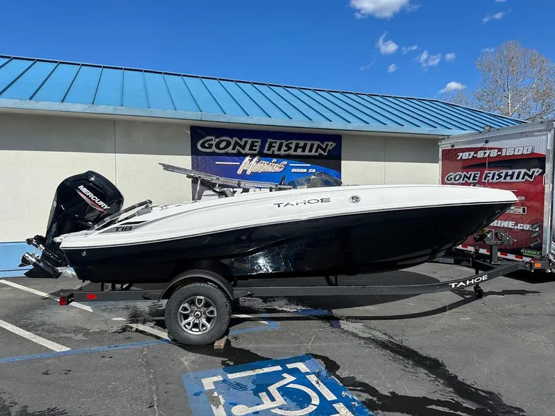Slide: The Image of 2025 Tahoe T18 boat on trailer at dealership, blue sky background. - 0