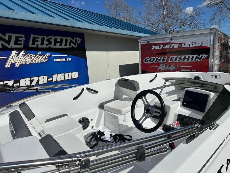 Slide: The Image of 2025 Tahoe T18 boat interior at Gone Fishin' Marine dealership, featuring steering wheel and seating. - 2