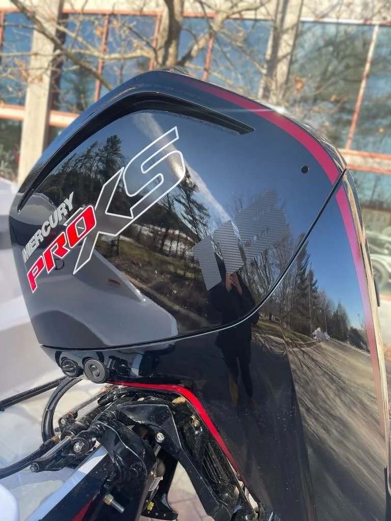 Slide: The Image of 2025 Tahoe T18 with Mercury Pro XS outboard motor, reflecting trees and building. - 3