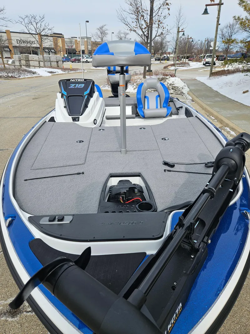 Slide: The Image of 2025 Nitro Z18 boat with blue accents, parked on a snowy street. - 2