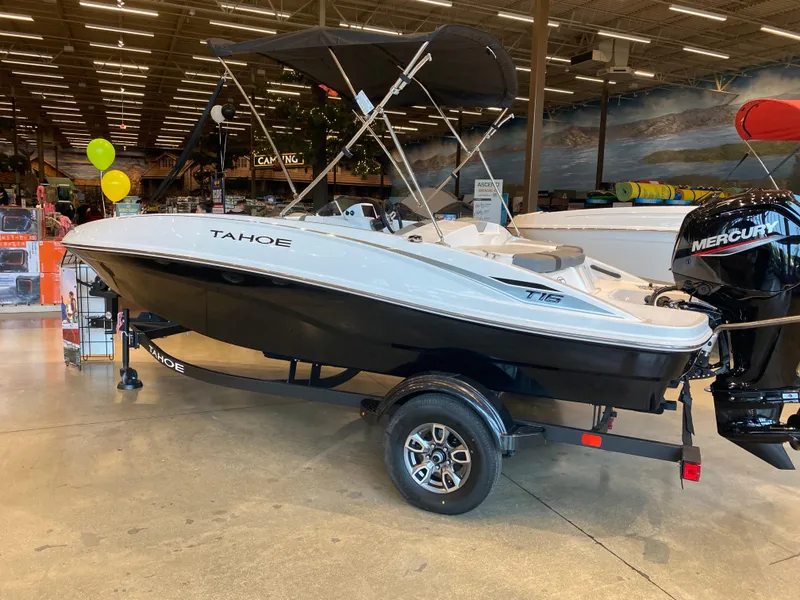 Slide: The Image of 2025 Tahoe T16 boat displayed indoors with Mercury outboard motor. - 1