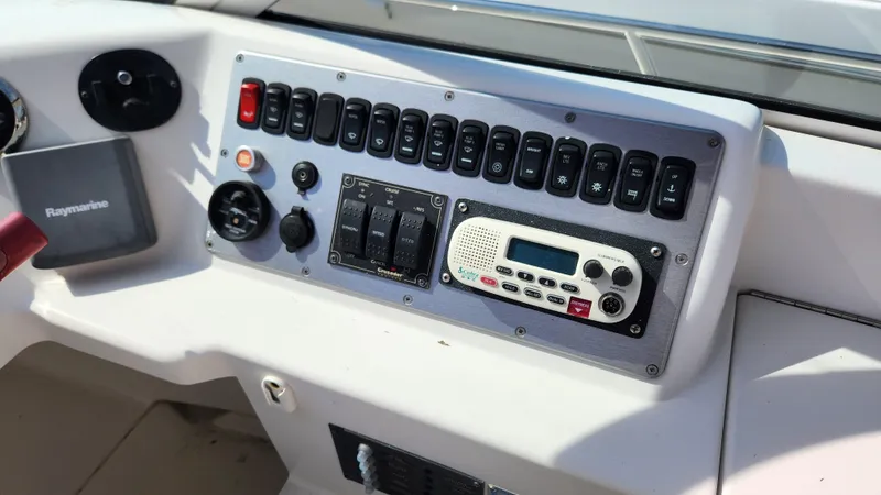 Slide: The Image of Control panel of a 2008 Carver 36 Mariner boat with various switches and a radio. - 20