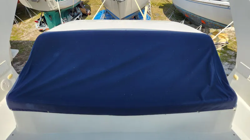 Slide: The Image of 2008 Carver 36 Mariner boat with blue cover, docked among other boats. - 26