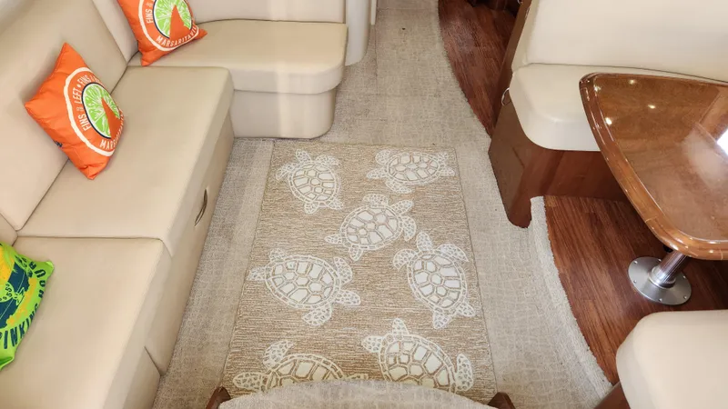 Slide: The Image of Interior of 2008 Carver 36 Mariner with beige seating and turtle-patterned rug. - 31