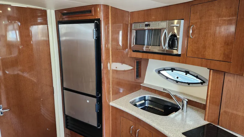 Slide: The Image of 2008 Carver 36 Mariner kitchen with wood cabinetry, stainless appliances, and oval window. - 40