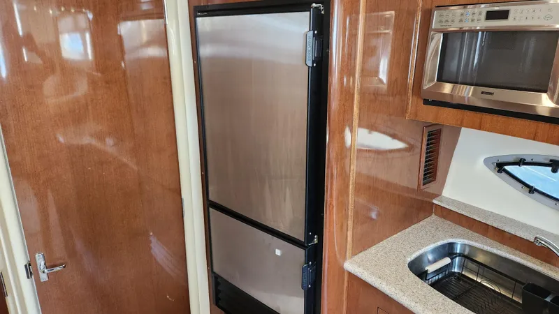 Slide: The Image of 2008 Carver 36 Mariner kitchen with stainless steel appliances and wood cabinetry. - 42